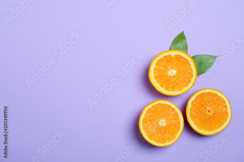 Flat lay composition with oranges and leaves on color background. Space for text