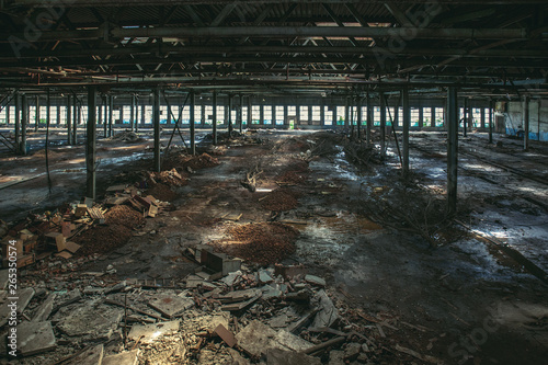 Abandoned large industrial hall or warehouse with garbage, ruined factory