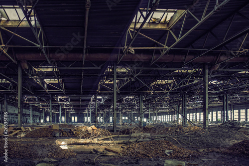 Abandoned large industrial hall or warehouse with garbage, ruined factory