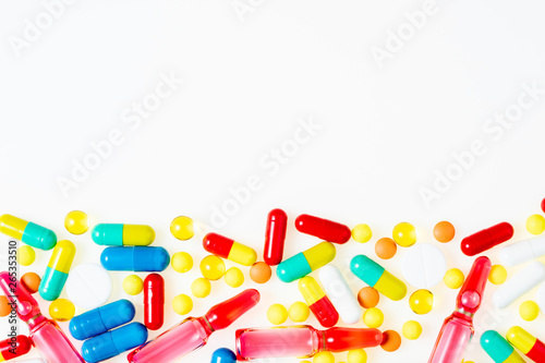 Assorted pharmaceutical medicine pills, tablets, ampoule and capsules on white background top view. Medical background. Flat lay, copy space