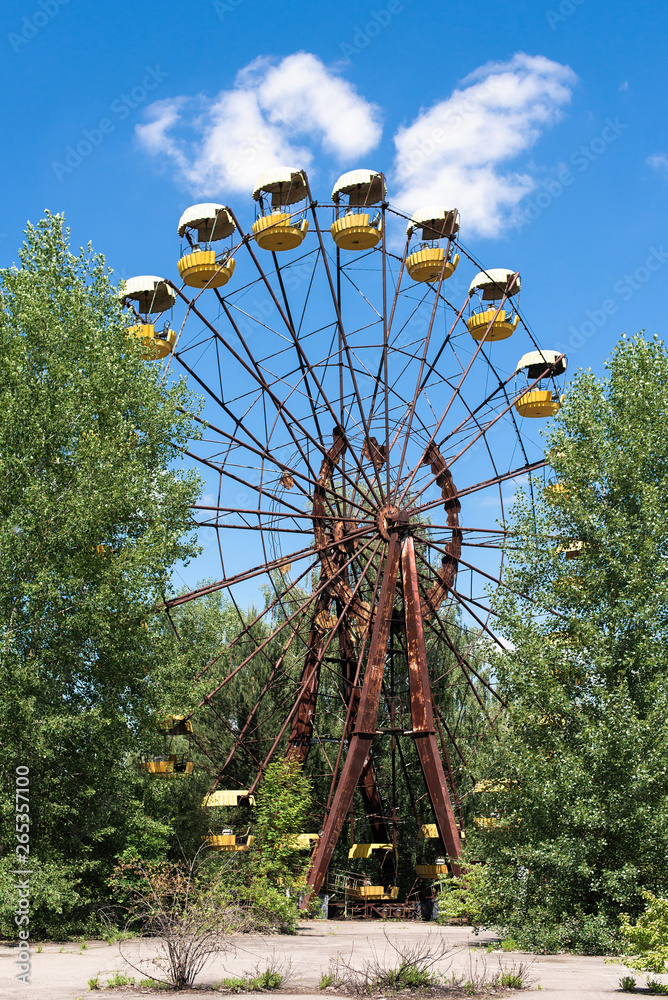 Abandoned carousel and abandoned ferris at an amusement park in the center of the city of Pripyat, the Chernobyl disaster, the exclusion zone, a ghost town