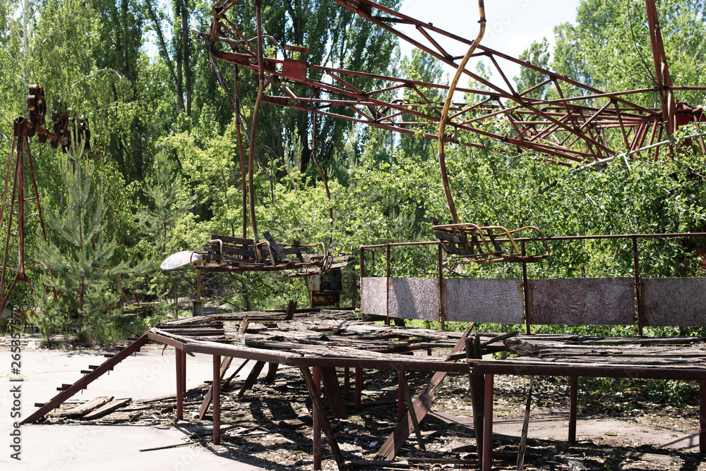 Abandoned carousel and abandoned ferris at an amusement park in the center of the city of Pripyat, the Chernobyl disaster, the exclusion zone, a ghost town