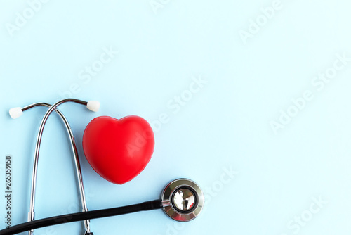 Directly Above Stethoscope And Heart Shape on Blue Background - Medical and Insurance Concepts © cn0ra