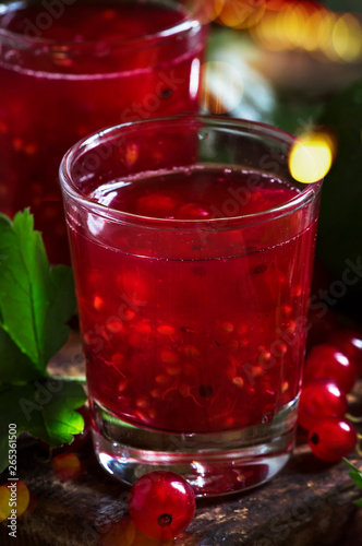 Red currant cocktail with juice, vodka and lime on dark table, top view
