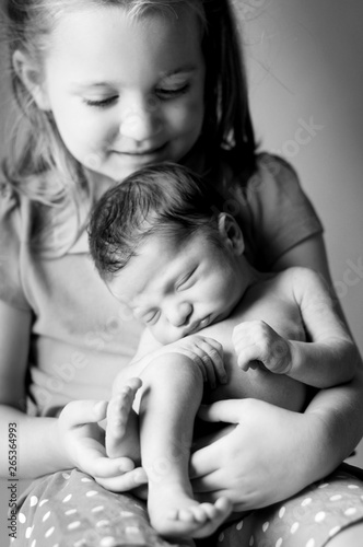Newborn Baby Held by Big Sister