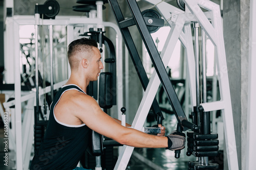 portrait of sporty girl workout on exercise machine in gym. Pretty young man training in the gym