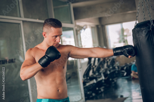 young strong sports man boxer make exercises in gym