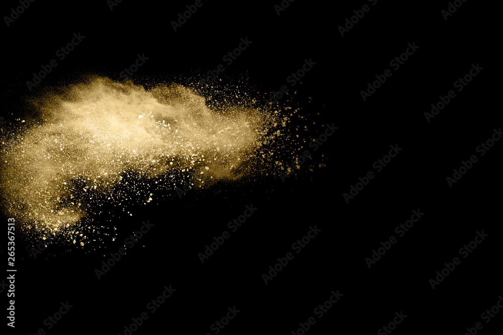 Golden powder explosion on black background. Freeze motion.