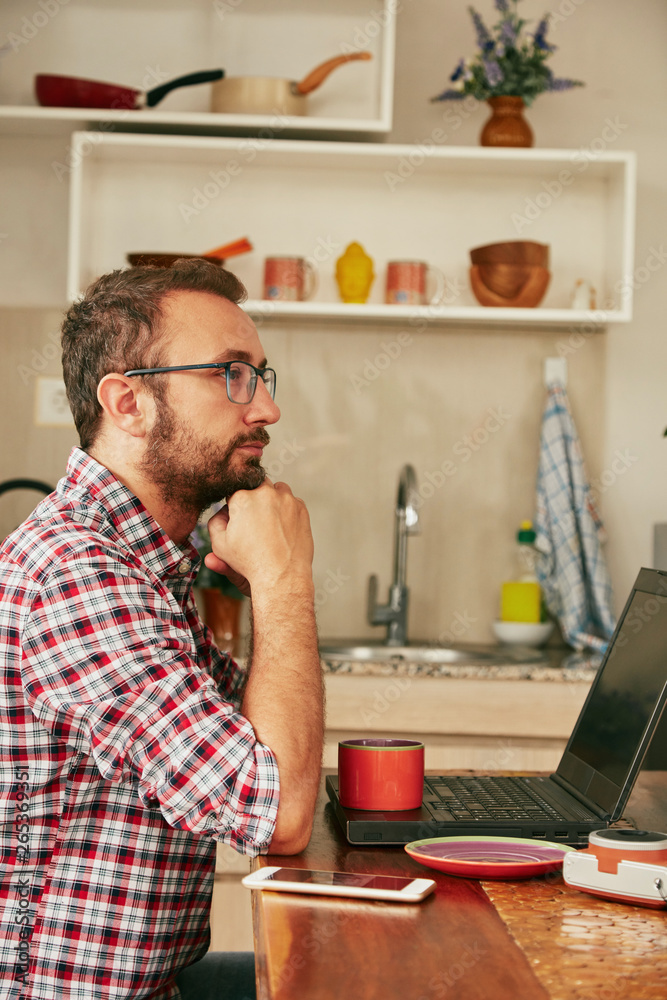 Modern bearded man using cellphone and drinking coffee with laptop. Modern bearded man using cellphone and drinking coffee with laptop.