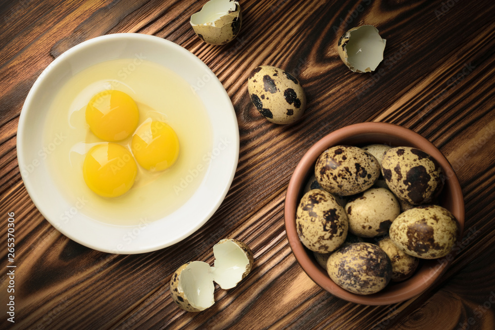 Top view yolks and whites of quail eggs in a plate and a bowl filled with eggs on a wooden table Top view yolks and whites of quail eggs in a plate and a bowl filled with eggs on a wooden table