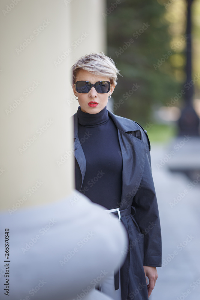 Stylish attractive girl in sunglasses posing on camera.