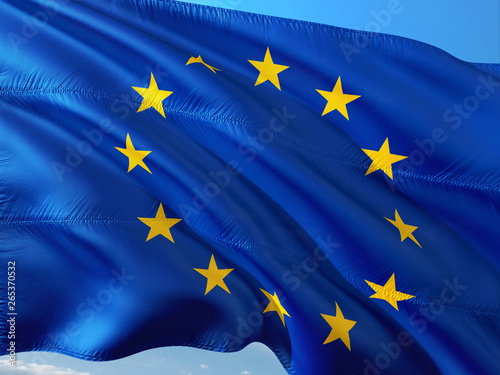 Flag of European Union waving in the wind against deep blue sky. High quality fabric.