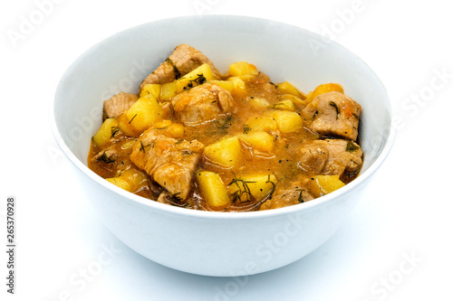 Stir with a spoon ragout with broth. Ragout of organic potatoes and beef. A bowl of beef stewed and potatoeson isolated white background.