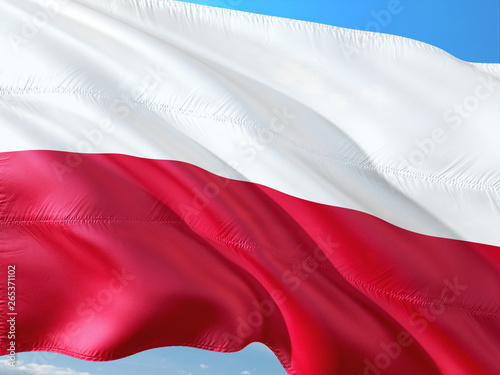 Flag of Poland waving in the wind against deep blue sky. High quality fabric.