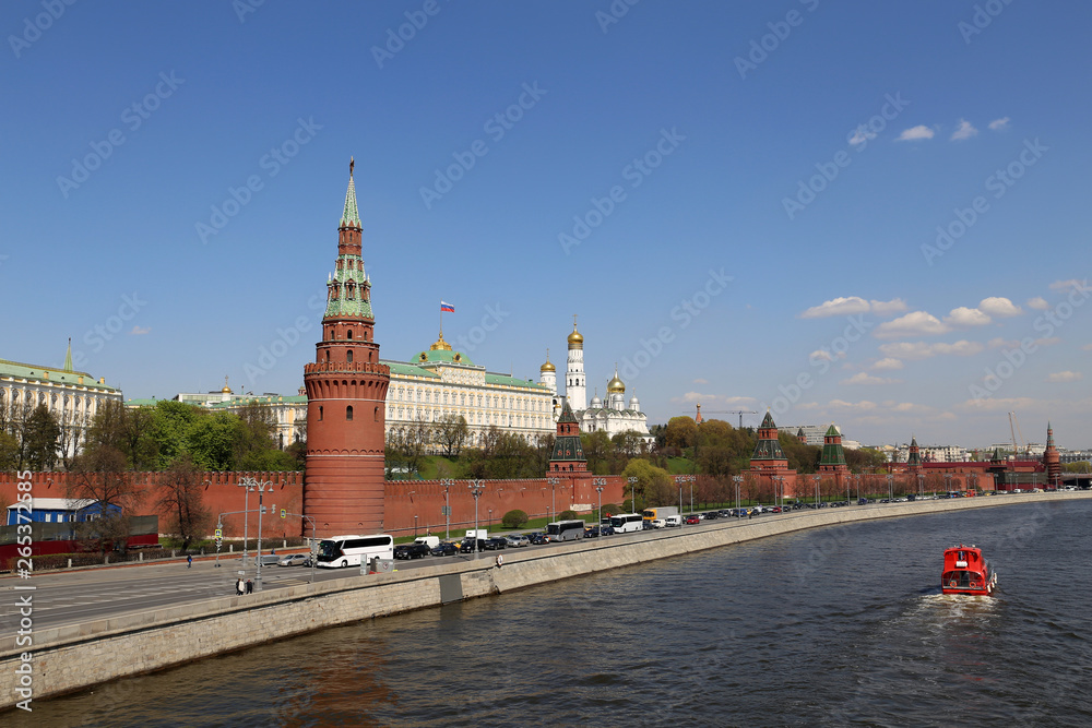View of the Moscow Kremlin and Moscow river in spring. Picturesque city panorama with blue sky and tourist boat, travel in Russia