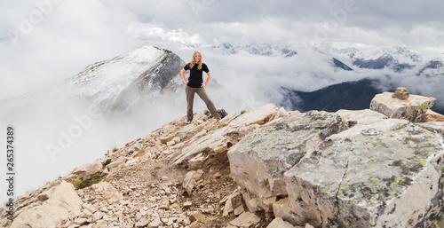 A Female Hiker Poses Alone For An Adventurous Portrait At The Peak Of A Mountain On The Hiking Trails Of Kicking Horse Mountain In The Rocky Mountains; British Columbia, Canada photo