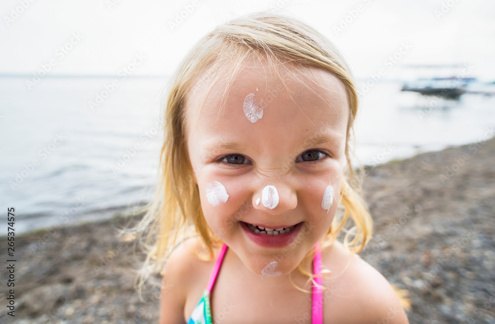 A Young Caucasian Girl With Sunscreen On Her Face Poses For A Picture At Seneca Lake; Dresden, New York, United States Of America A Young Caucasian Girl With Sunscreen On Her Face Poses For A Picture At Seneca Lake; Dresden, New York, United States Of America