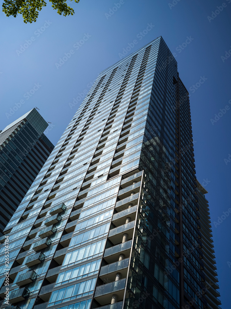 Low Angle View Of A Residential Skyscraper Against A Blue Sky; Toronto, Ontario, Canada Low Angle View Of A Residential Skyscraper Against A Blue Sky; Toronto, Ontario, Canada