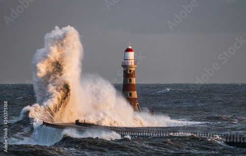 Waves Splashing Against Roker Lighthouse At The End Of A Pier; Sunderland, Tyne And Wear, England photo