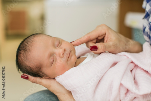 Newborn baby in mother's arms in the Neonatal Intensive Care Unit; Surrey, British Columbia, Canada photo