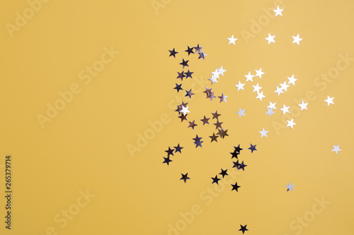 Star-shaped confetti scattered on a yellow background. Celebration and party, concept. Copy space © Alexander