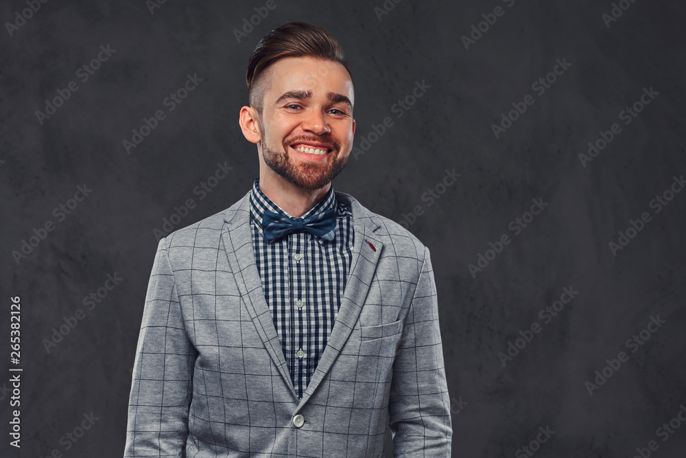 Fototapeta premium Studio shoot of smart smiling man in checkered blazer and shirt with bow.