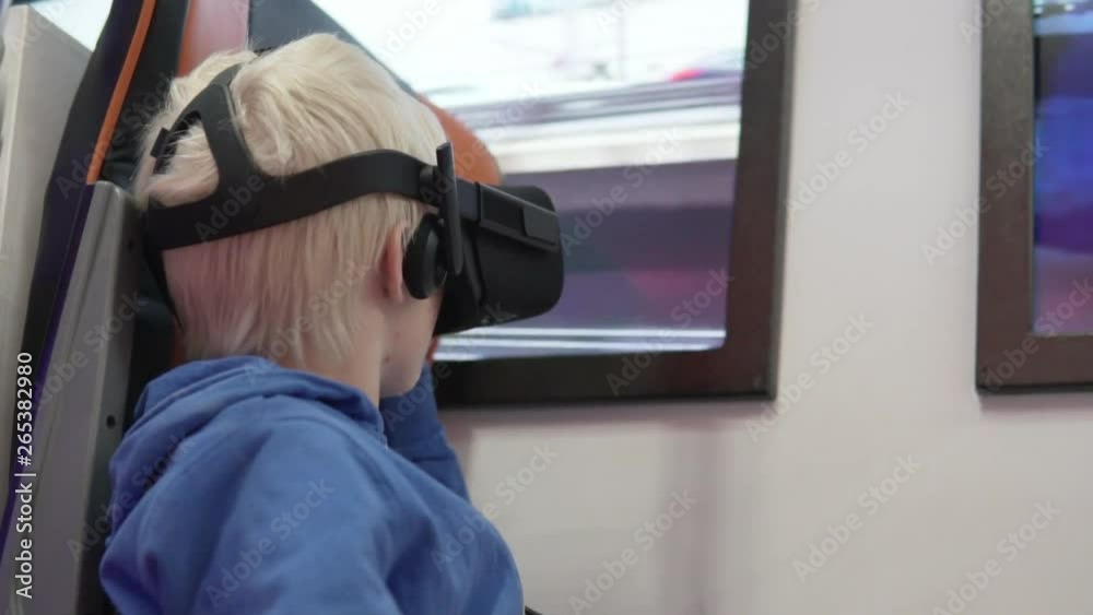 Malik blond with glasses of virtual reality. The child presents himself to the subway train drivers. He sits in a chair and looks into his glasses vr Malik blond with glasses of virtual reality. The child presents himself to the subway train drivers. He sits in a chair and looks into his glasses vr