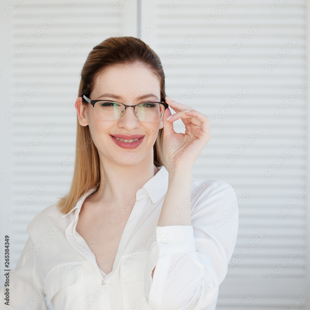 Young business lady in white shirt and glasses. Attractive young woman smiling Young business lady in white shirt and glasses. Attractive young woman smiling