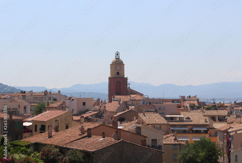 View of the historical streets of Saint-Tropez. The tiled roofs and the belfry of the church of Saint-Tropez.