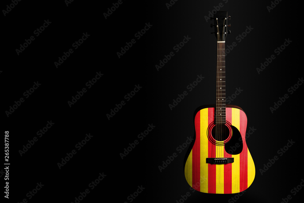 Acoustic concert guitar with a drawn flag Catalonia, on a dark background, as a symbol of national creativity or folk song.