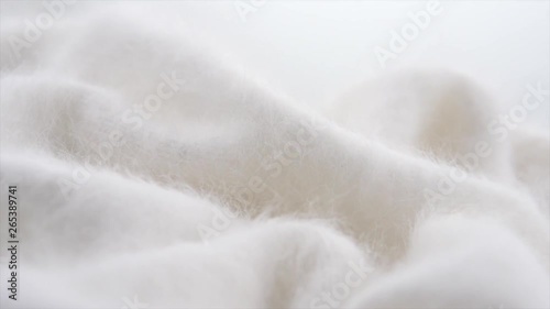 Soft wool background. Alpaca wool mohair clothes texture closeup. Natural cashmere fluffy merino wool. Woolen fabric. Rotated. 4K UHD video footage. 3840X2160 photo