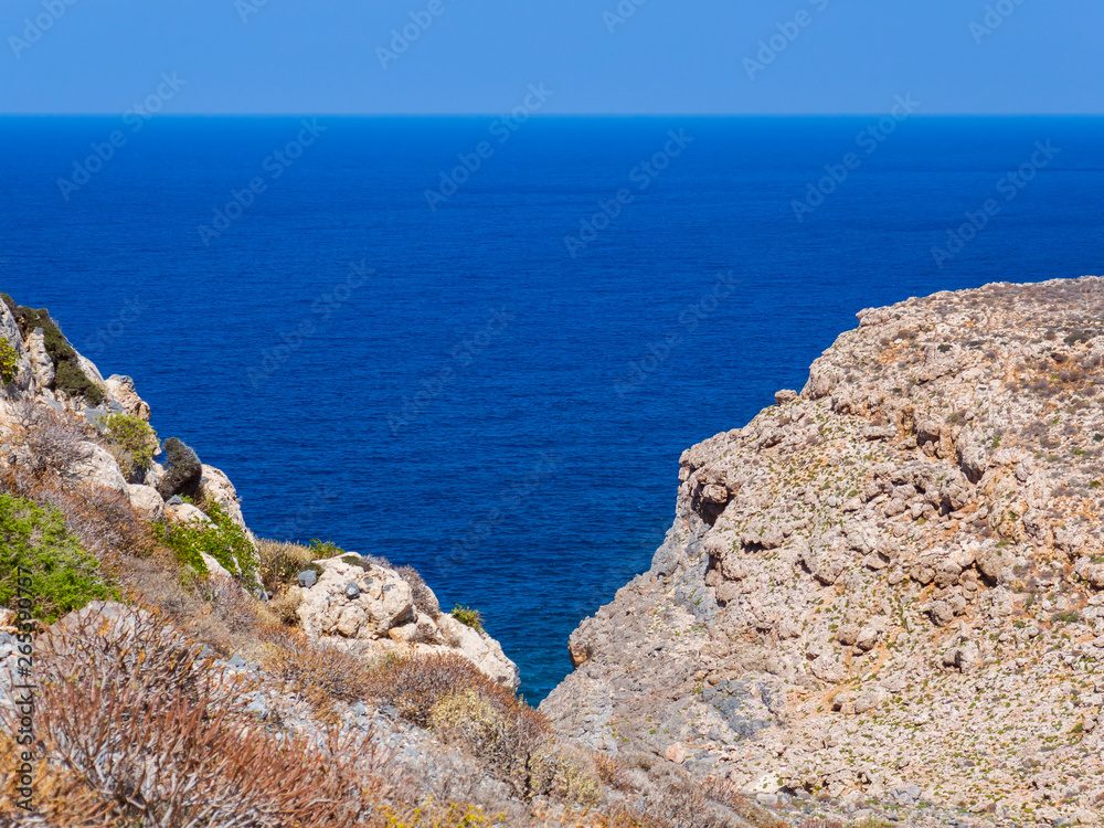 Beautiful blue sea, rocky hills in the foreground