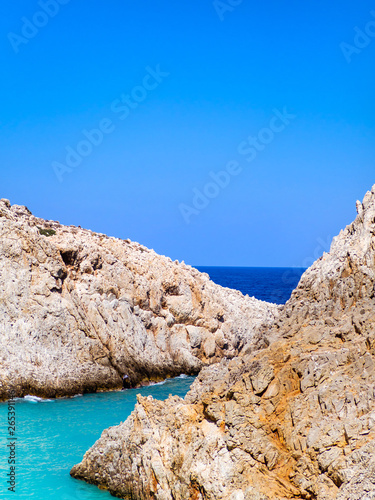 Sharp rocky edges and beautiful different shades of blue sea waters of Crete, Greece