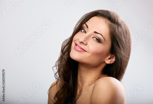 Beautiful natural makeup calm smiling woman with long hair style. Skincare concept. Closeup portrait on blue background
