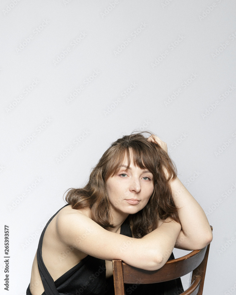 Fototapeta premium Woman in black dress on white background with filmgrain