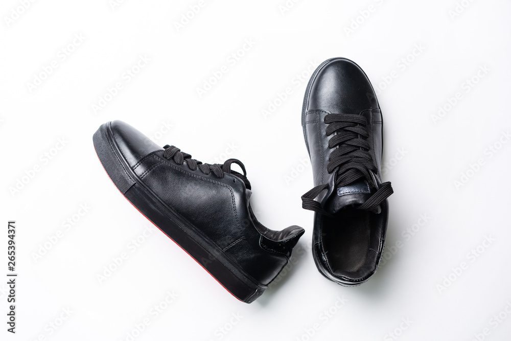 a pair of black trendy sneakers on the white background