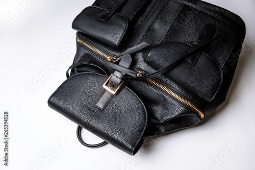 black leather backpack with golden zipper pockets on a white background