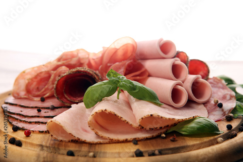 Food tray with delicious salami, pieces of sliced ham, sausages,salad and vegetable. Meat platter with selection