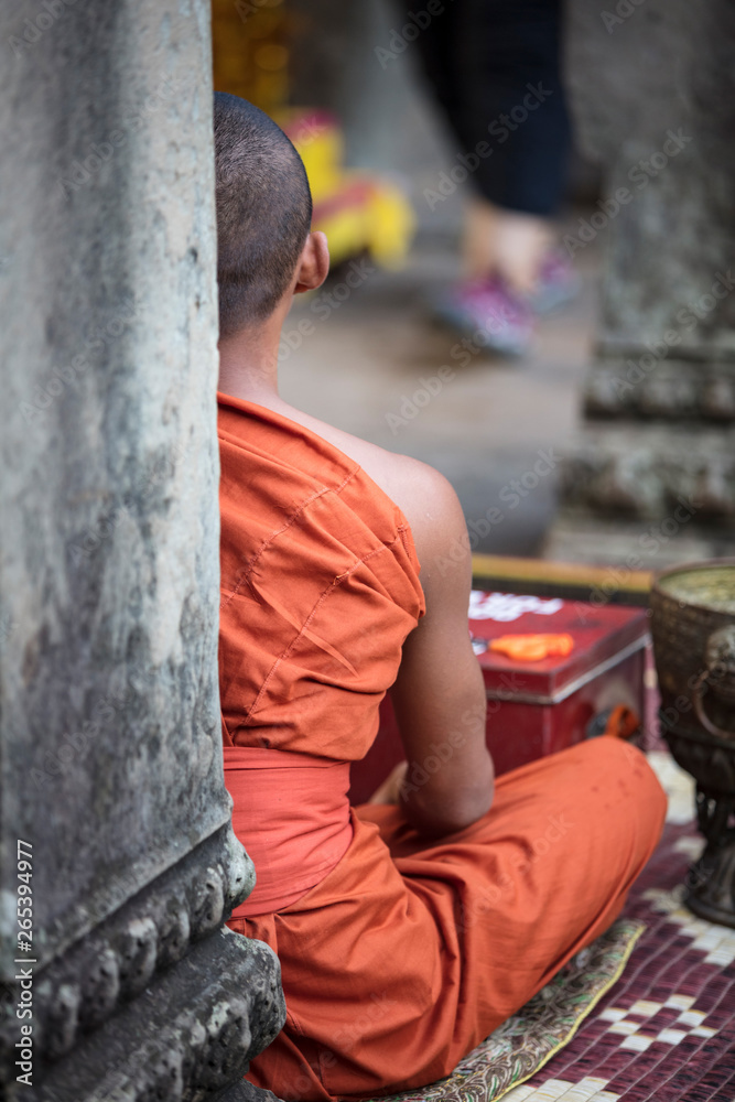 Buddhist monk offering blessings and accepting donations at Angkor Wat temple, Siem Reap, Cambodia