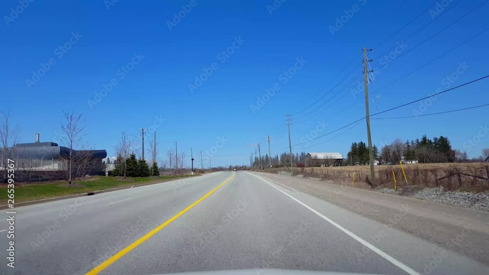 Driving Rural Road Along Farmland During Spring Day. Driver Point of View POV Beautiful Sunny Countryside Farm Fields. Driving Rural Road Along Farmland During Spring Day. Driver Point of View POV Beautiful Sunny Countryside Farm Fields.