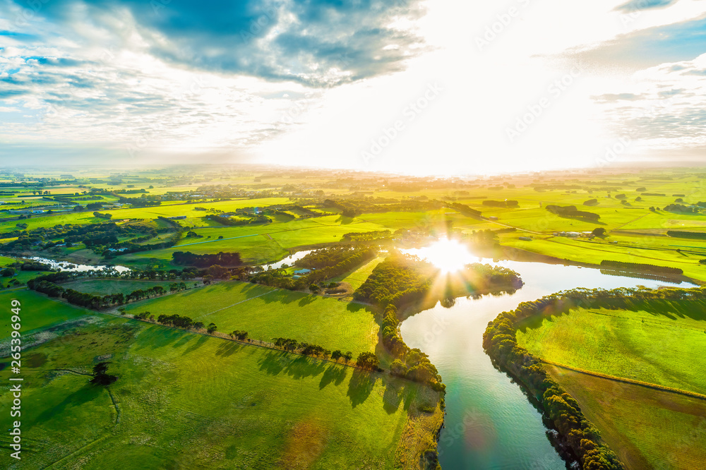 Bright sunset over scenic river in lush green countryside