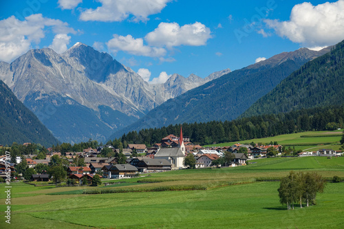AERIAL: Flying over the empty meadows and towards an idyllic village in Austria.