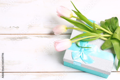 Fototapeta Naklejka Na Ścianę i Meble -  pink tulips on a gift box on a white wooden table