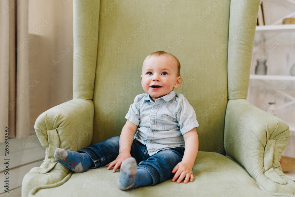 Cute little toddler boy sitting in armchair Cute little toddler boy sitting in armchair