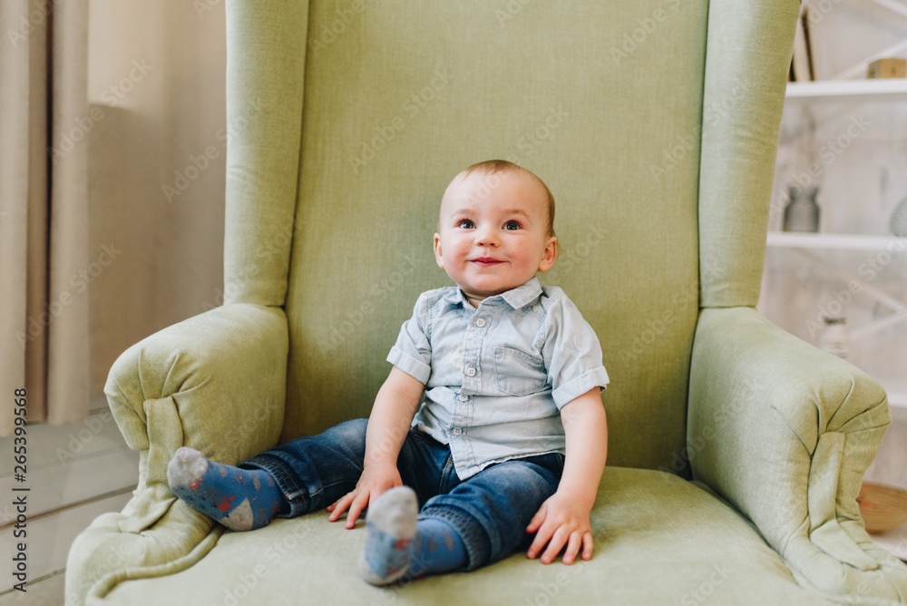 Cute little toddler boy sitting in armchair Cute little toddler boy sitting in armchair