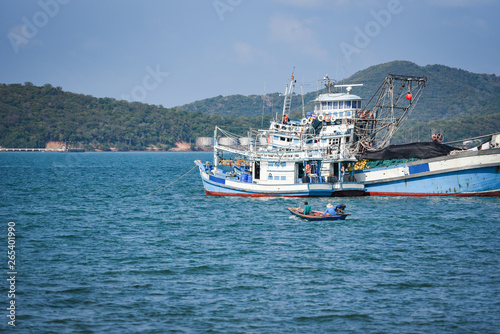 fishing boat at harbor in the ocean sea and mountain background in thailand