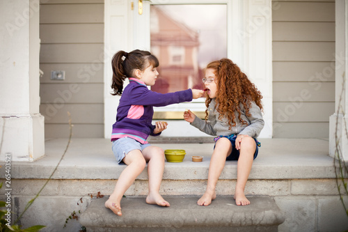 Little Girl Sharing a Snack with Her Sister photo