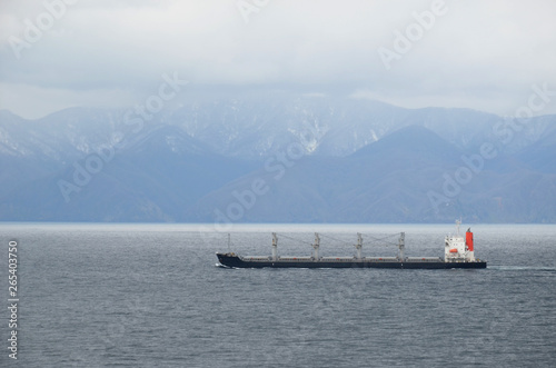 Small cargo ship sailing near Japanese island Hokkaido.