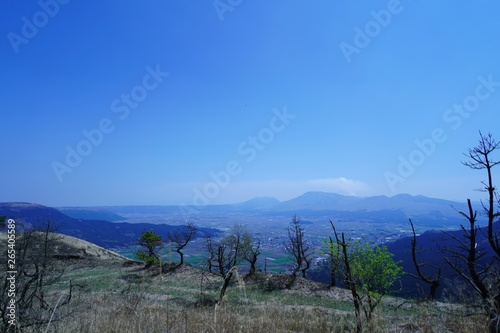 噴煙を放つ阿蘇山と阿蘇町の風景