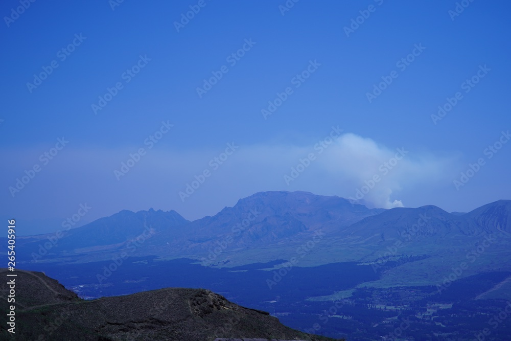 噴煙を放つ阿蘇山と阿蘇町の風景